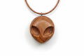 Alien pendant carved from elm wood - flat lay product photo on white background