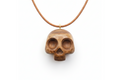 Handcrafted dark walnut wood skull pendant on leather cord against white background