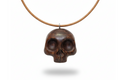 Handcrafted wengé skull pendant with dark brown wood grain and natural finish on white background