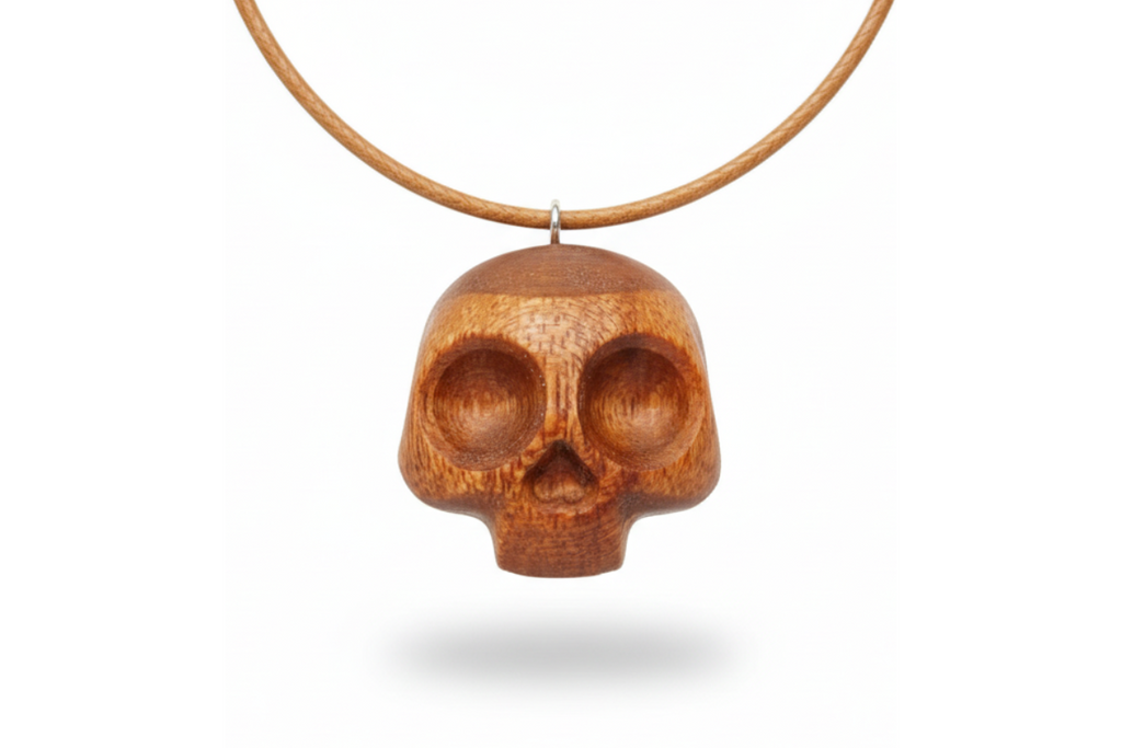 Handcrafted red oak skull pendant showing detailed carving and natural wood texture