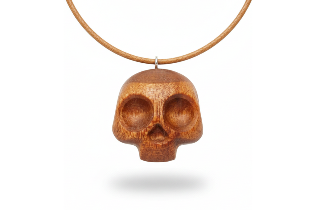 Handcrafted red oak skull pendant showing detailed carving and natural wood texture