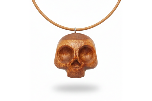 Handcrafted red oak skull pendant showing detailed carving and natural wood texture